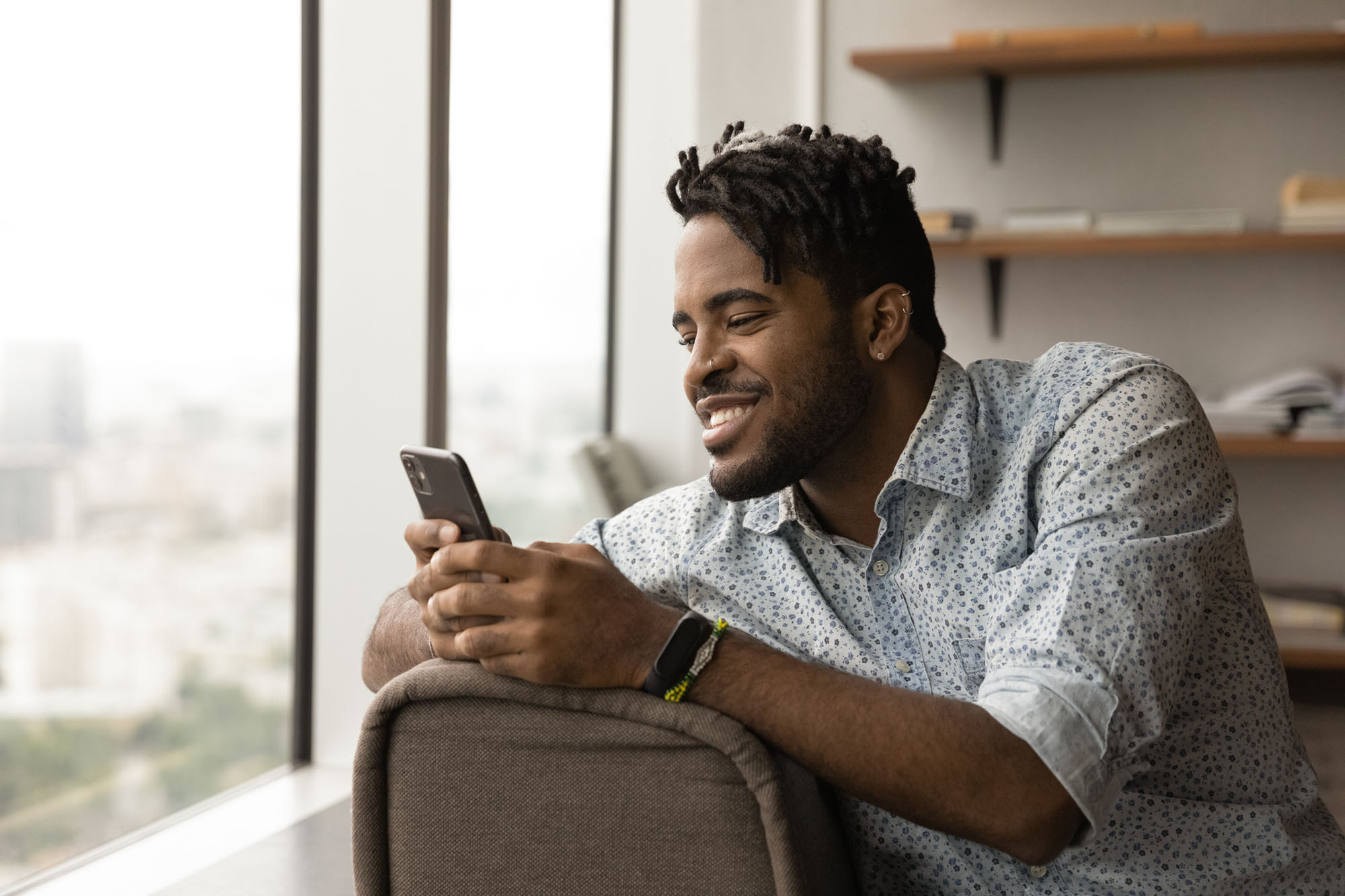 Smiling African American man use cellphone texting